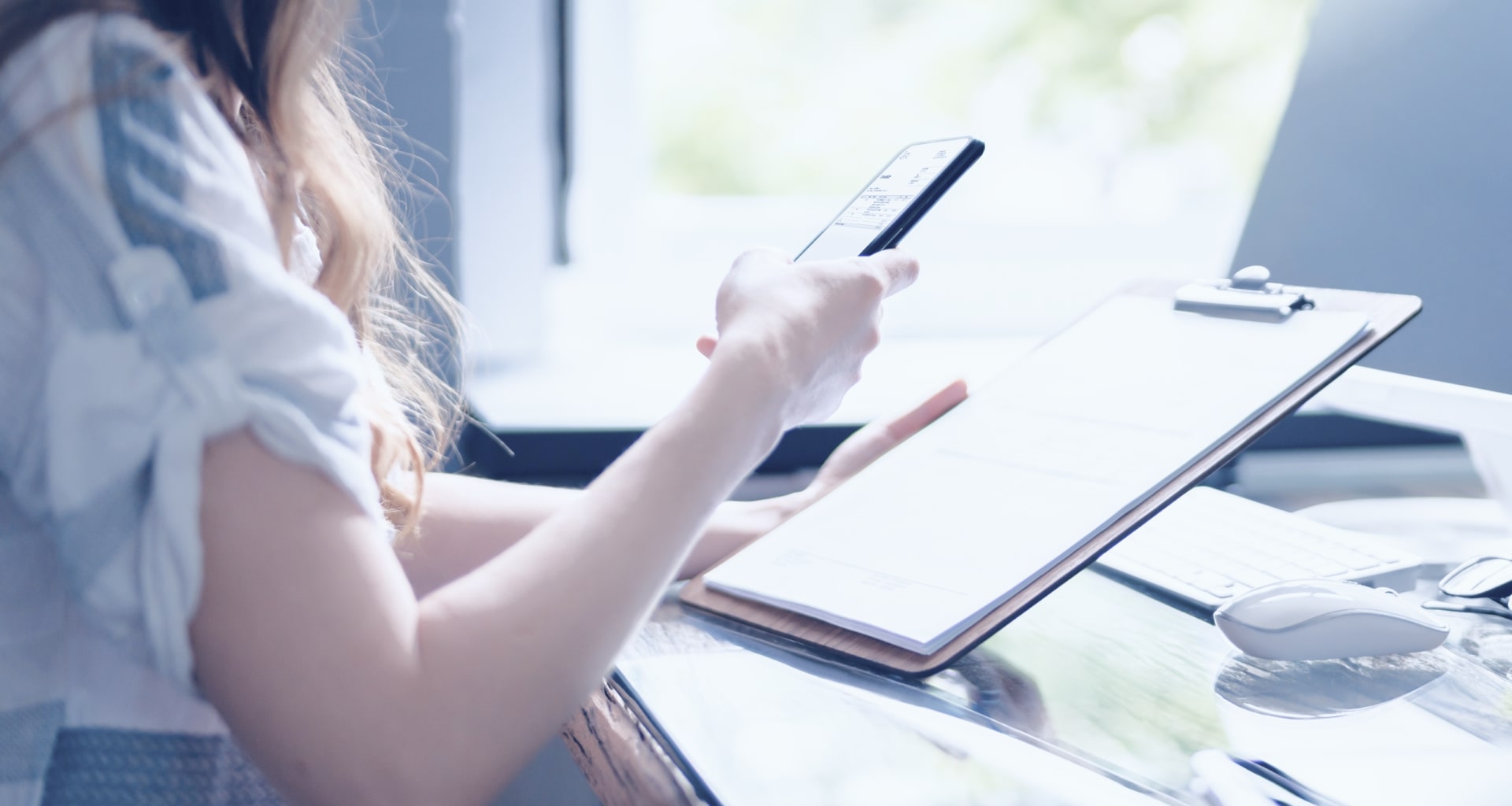 Woman scanning a document on her phone, demonstrating mobile capture technology.